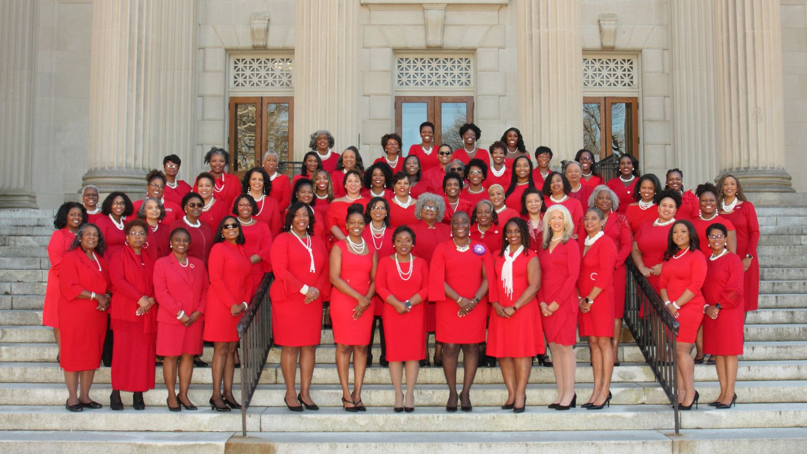 2023 Chapter Picture. Women in red standing on steps on the campus of UNC.